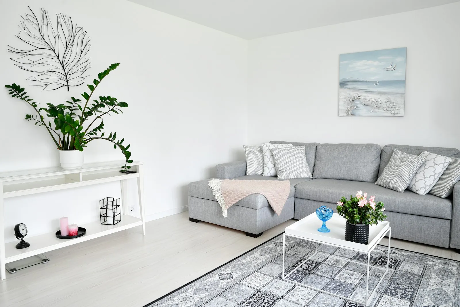 Helles, freundliches Wohnzimmer mit grauem Sofa, Konsolentisch und freier Wandfläche